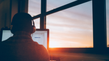 Someone using a computer during a sunset